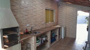 a kitchen with a sink and a brick wall at Villa Caiçara in Ubatuba +25 photos