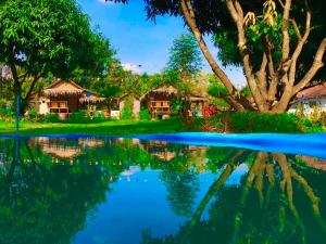 a view of a resort with a reflection in the water at เดอะกระต็อบ By The Mountain Ozone บ้านโอโซนขุนเขาแก่งกระจาน in Ban Song Phi Nong