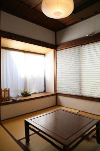 um quarto com uma mesa em frente a uma janela em Guest House Kamejikan em Kamakura