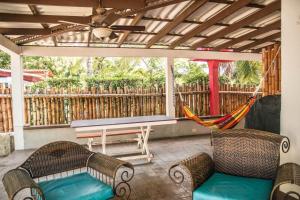 a porch with a hammock and a bench at Bed & Surf House El Palmar in Las Palmeras