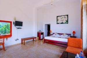 1 dormitorio con 1 cama, 1 silla y TV en Thuruliya Hotel, en Ramboda