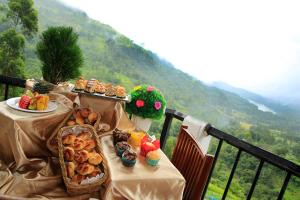 a table with food on top of a balcony at Thuruliya Hotel in Ramboda