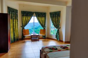 a room with a bed and a table and a window at Thuruliya Hotel in Ramboda