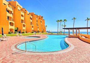 a swimming pool in front of a building at Right on the Beach! Rocky Point Condo Rental - 2 Bedroom Penthouse Beachfront in Puerto Peñasco