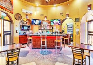 a bar in a restaurant with wooden tables and chairs at Right on the Beach! Rocky Point Condo Rental - 2 Bedroom Penthouse Beachfront in Puerto Peñasco
