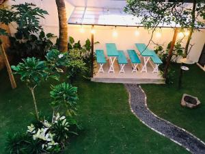 een patio met stoelen en een tafel in de tuin bij Double Mango Villa in Katunayaka