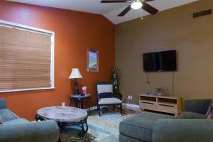 a living room with a couch and a flat screen tv at Quiet desert getaway with ping-pong, BBQ, citrus in Phoenix