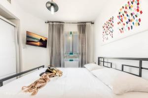 a bedroom with a large white bed with a large window at Luxury Apartment on the Lake in Tiberias