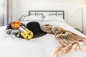 a white bed with a hat and a bottle on it at Luxury Apartment on the Lake in Tiberias