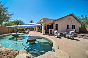 una piscina con sombrilla y un patio en Tranquil retreat with pool, billiards, putting green, en Scottsdale