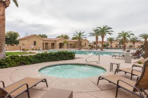 a swimming pool with chairs and a resort at Gated townhouse with heated pool, hot tub, near US60 in Mesa