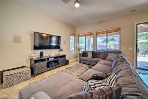 sala de estar con sofá y TV de pantalla plana en Tranquil retreat with pool, billiards, putting green, en Scottsdale