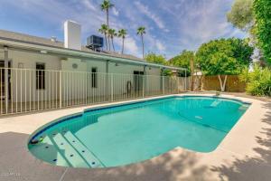 una piscina frente a una casa en Quiet house with pool heater, patio, BBQ, citrus en Phoenix