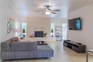 sala de estar con sofá y TV de pantalla plana en Quiet house with pool heater, patio, BBQ, citrus en Phoenix