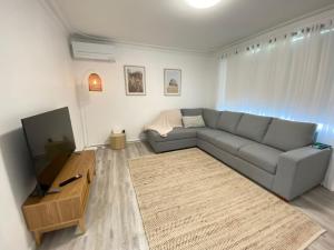 uma sala de estar com um sofá e uma televisão de ecrã plano em Peppermint Cottage em Broadwater