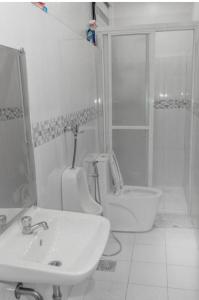 a bathroom with a sink and a toilet and a shower at Casa Martina in Cotabato