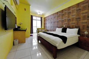 - une chambre avec un lit et une télévision à écran plat dans l'établissement Chu Dream Hostel, à Hualien