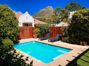a swimming pool in front of a house with a fence at 5 Camp Street Guesthouse & Self-catering in Cape Town