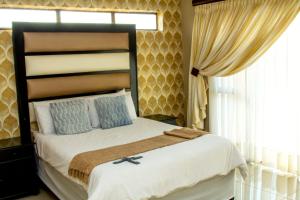 a bedroom with a large bed with a large window at Vakhusi Guesthouse in Malamulele