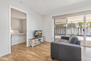 a living room with a couch and a tv and a bed at Sea-Hi Beachside Apartment in Maroochydore