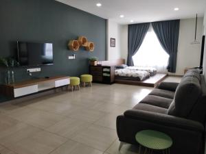 a living room with a couch and a television at The Octagon Ipoh in Ipoh