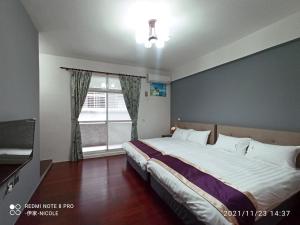 Postel nebo postele na pokoji v ubytování 伊家民宿Yi home 志航路一段398號
