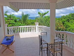 a porch with a table and chairs on a balcony at Sofias House Rental in Tagbilaran City