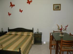 a bedroom with a bed and a desk and a table with a bed at Appartamenti Holiday Housing Lipari Centro in Lipari