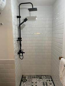 uma casa de banho com um chuveiro com azulejos brancos em APARTEMEN MURAH DAN UNIK em Bandung