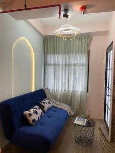 um sofá azul numa sala de estar com uma janela em APARTEMEN MURAH DAN UNIK em Bandung
