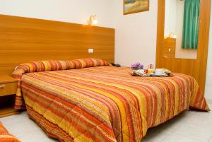 a bedroom with a large bed with a wooden headboard at Hotel California in Ariccia