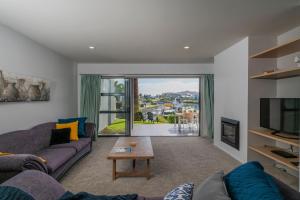 a living room with a couch and a tv at Hosts on the Coast Delight by the Pier in Whitianga