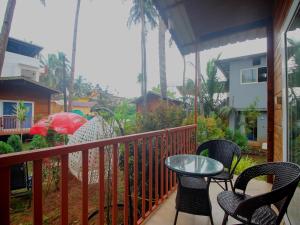 a balcony with chairs and a table on a porch at Mariners Bay Beach Resort in Arambol