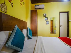 a bedroom with a bed with blue pillows on it at Mariners Bay Beach Resort in Arambol