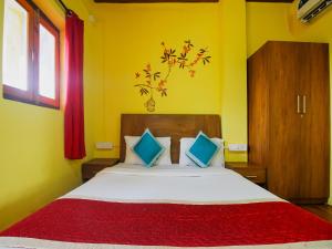 a bedroom with a large bed with yellow walls at Mariners Bay Beach Resort in Arambol