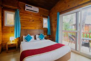 a bedroom with a bed and a large window at Mariners Bay Beach Resort in Arambol