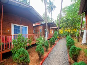 a house with trees and bushes in front of it at Mariners Bay Beach Resort in Arambol