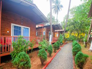 a house with trees and bushes in front of it at Mariners Bay Beach Resort in Arambol