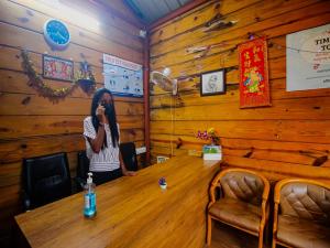 a woman sitting at a table talking on a cell phone at Mariners Bay Beach Resort in Arambol