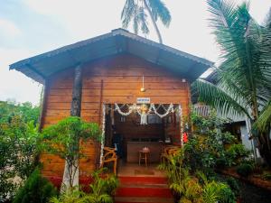 a small wooden house with a table in front of it at Mariners Bay Beach Resort in Arambol