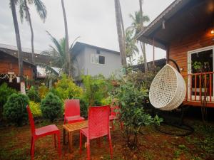 a group of chairs and a table in a yard at Mariners Bay Beach Resort in Arambol