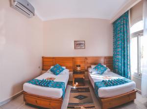 a bedroom with two twin beds and a table at Sheikh Ali Dahab Resort in Dahab