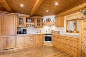 Il comprend une grande cuisine avec des placards en bois et du parquet. dans l'établissement Ferienwohnung Rubin, à Mittenwald