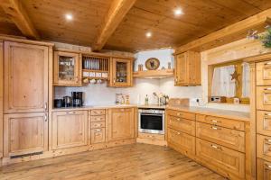 a large kitchen with wooden cabinets and a wooden floor at Ferienwohnung Rubin in Mittenwald