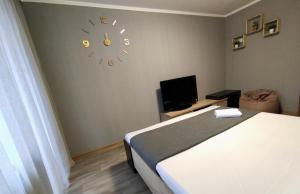 1 dormitorio con 1 cama y reloj en la pared en Двухкомнатные апартаменты центр Mystetsʹka 3 KR Apartments, en Krivoy Rog