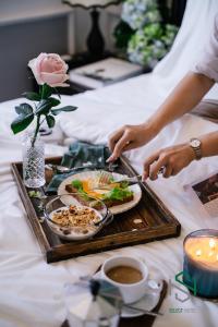 a person cutting a plate of food on a tray at Selecthotel Hạ Long in Ha Long