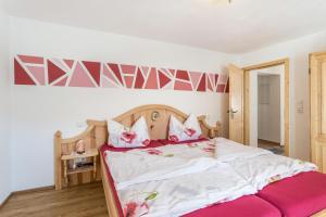 una camera da letto con un grande letto con cuscini rosa di Ferienwohnung Granat a Mittenwald