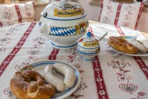 una mesa cubierta con platos de donas y una tetera en Ferienwohnung Granat en Mittenwald