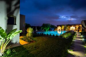 - une vue sur la piscine la nuit dans l'établissement Villa Jardins D'Isa, à Marrakech