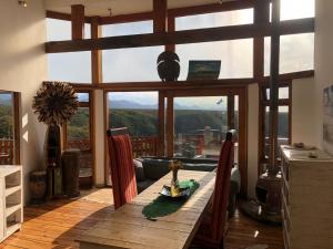 uma sala de jantar com uma mesa e uma grande janela em Rainforest Ridge Eco Resort em The Crags